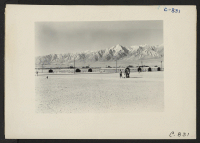 [recto] Manzanar, Calif.--General view of this War Relocation Authority center located in the Owens Valley looking east across the wide fire-break which separates blocks of barracks. ;  Photographer: Lange, Dorothea ;  Manzanar, California.