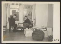 [recto] Two friends play final game while awaiting evacuation. Evacuees of Japanese descent are being housed in War Relocation Authority centers for the duration. ;  Photographer: Lange, Dorothea ;  San Francisco, California.