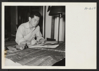 [recto] Henry Omachi, a young student of engineering from the Tule Lake Center, now relocated in Cleveland and employed by the National Surveys Company, is here seen at his drafting desk. ;  Photographer: Mace, Charles E. ;  Cleveland, Ohio.