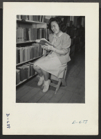[recto] Mary Nakagaki studying in the library at this center. Former occupation: student. Present occupation: student. Former residence: Rio Vista, California. ;  Photographer: Stewart, Francis ;  Rivers, Arizona.