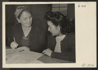 [recto] Mrs. Chlde Zimmerman, clerk, aiding Fumi Ido in registering for indefinite leave. Present occupation: kitchen work. Former occupation: cannery work. Former residence: Terminal Island, Calif. ;  Photographer: Stewart, Francis ;  Manzanar, California.