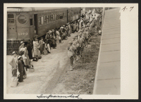 [recto] Persons of Japanese ancestry arrive at the Santa Anita Assembly Center from San Pedro, California. Evacuees lived at this center at the Santa Anita race track before being moved inland to relocation centers. ;  Photographer: Albers, Clem ;  Arcadia, C