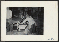 [recto] Adobe factory. A woman worker placing mortar in adobe form. ;  Photographer: Stewart, Francis ;  Poston, Arizona.
