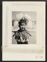 [recto] Bobby Kaneko, 4. Little Bobby wears a head dress which was part of his costume in the Labor day Parade. His nursery school class used the theme of Mary, Mary Quite Contrary, and Bobby was one of Mary's little flowers. ;  Photographer: Stewart, Francis