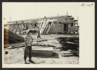[recto] Site No. 1. Larry Orida at the hospital being constructed at this War Relocation Authority center for evacuees of Japanese ancestry. ;  Photographer: Clark, Fred ;  Poston, Arizona.