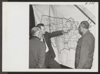 [recto] Harold Fistere, Relocation Supervisor from Cleveland, and Elmer Shirrell, Relocation Supervisor from Chicago, discuss their respective areas with an evacuee during a recent visit of a Relocation Team to Rohwer Relocation Center. ;  Photographer: Van Tas