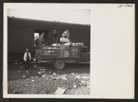 [recto] A truck load of freight being put aboard a train for shipment to the Heart Mountain Center. The loading of cars was under the supervision of the wardens. One is shown at the left. ;  Photographer: Mace, Charles E. ;  Newell, California.