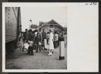 [recto] A scene at the little railway station of Delta, Utah, as transferees from the Topaz Center entrain for Tule Lake. One of the center's nurses is shown in attendance. ;  Photographer: Mace, Charles E. ;  Topaz, Utah.