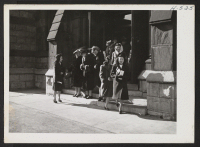 [recto] Young Chicago resettlers get acquainted with their fellow church members after the Sunday service. Here we see several Niseis leaving the entrance of the Second Presbyterian Church on Chicago's Michigan Boulevard. ;  Photographer: Mace, Charles E. ;