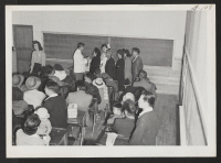 [recto] OUTGOING--Medical checkup of departees in school room. ;  Photographer: Aoyama, Bud ;  Heart Mountain, Wyoming.
