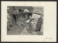 [recto] Early arrivals preparing benches and make shift seats to provide temporary furniture in their barracks. Former residence: Merced Assembly Center, Merced, California. ;  Photographer: Parker, Tom ;  Amache, Colorado.