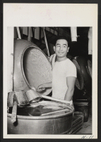 [recto] Henry Legoro, 22, relocated in Chicago from the Jerome Center, is here shown at his new job in a large candy factory. He was formerly a farmer at Fresno, California. He has a brother at Camp Savage in the Intelligence Service. ;  Photographer: Mace, Cha