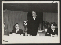 [recto] The Rev. E. Stanley Jones, Head of the Traveling Missionary Team, addresses assembled audience at Central Utah Relocation Center during visit on October 28, 1943. At speaker's table seated left to right are Dr. Skoglund, Rev. E. Stanley Jones, Dave Tatsun