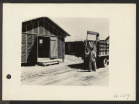 [recto] Poston, Ariz. (Site #1)--Unloading beds for evacuees of Japanese ancestry at this War Relocation Authority center which is located on the Colorado River Indian Reservation. ;  Photographer: Clark, Fred ;  Poston, Arizona.