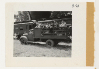 [recto] A truck load of young evacuees leaving the Granada railroad station bound for the relocation center 2-1/2 miles away. These evacuees were formerly from Merced Assembly Center, Merced, Calif. ;  Photographer: Parker, Tom ;  Amache, Colorado.