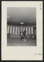 [recto] During an evening program, an evacuee entertainer demonstrates the ancient art of dish twirling. (See E-95) ;  Photographer: Parker, Tom ;  Heart Mountain, Wyoming.