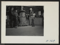 [recto] Community store in Block 30. Customers warming hands by stove. ;  Photographer: Stewart, Francis ;  Hunt, Idaho.
