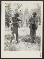 [recto] Two members of the 522nd field artillery telephone unit transmit messages during firing practice, on the extensive range at Camp ...