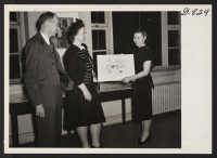 [recto] Miss Mine Okubo, Nisei, who resettled to New York from the Topaz Center, is showing one of her drawings to ...