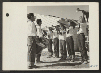 [recto] A section of the drum and bugle corps, a former Los Angeles Boy Scout Unit, performs at the dedication of the hospital at the Topaz Relocation Center. ;  Photographer: Parker, Tom ;  Topaz, Utah.