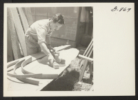[recto] George Nakashima, architect, laying out a form for bending wood to be used in chairs he is making. George, with ...