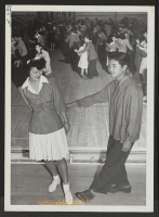 [recto] Tubbie Kunishima and Laverne Kurahara demonstrate some intricate jitterbug steps, during a school dance held in the High School gymnasium. ;  Photographer: Iwasaki, Hikaru ;  Heart Mountain, Wyoming.