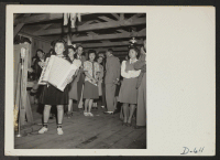 [recto] Manzanar, California --A young evacuee of Japanese ancestry entertains on an accordion at a dance given by the Girls' Recreation Committee for fellow evacuees. ;  Photographer: Stewart, Francis ;  Manzanar, California.