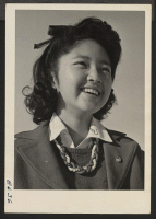 [recto] A young Nisei girl, Helen Hifumi, 13, a high school student at the Heart Mountain Center High School where classes are held temporarily in barracks blocks. ;  Photographer: Parker, Tom ;  Heart Mountain, Wyoming.