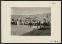 [recto] Manzanar, Calif.--Evacuees watching a baseball game at this War Relocation Authority center. This is a very popular recreation with 80 ...