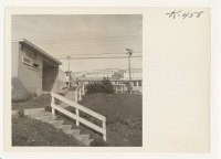 [recto] Entrance to the cafeteria and a section of the temporary housing units at Hunters Point in San Francisco, where returning ...