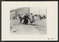 [recto] Members of two evacuee families of Japanese descent meet at this Assembly Center located on the Salinas Rodeo Grounds. These people will be transferred later to a War Relocation Authority center. ;  Photographer: Albers, Clem ;  Salinas, California.