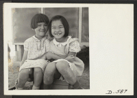 [recto] Poston, California--Little girls playing house at this War Relocation Authority center where evacuees of Japanese ancestry are spending the duration. (L to R) Ayako Nakamura, 9 yrs.; June Ibe, 6 yrs. ;  Photographer: Stewart, Francis ;  Poston, Arizon