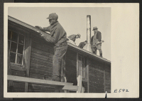 [recto] To increase school facilities, several abandoned CCC buildings were moved from a former CCC camp to the Heart Mountain Relocation Center. Here, resident workers are reassembling the buildings. ;  Photographer: Parker, Tom ;  Heart Mountain, Wyoming.