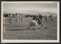 [recto] A snow covered hill forms the background for a hotly contested game between the Jack Rabbits and the All Stars at Heart Mountain Relocation Center. ;  Photographer: Iwasaki, Hikaru ;  Heart Mountain, Wyoming.