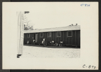 [recto] Manzanar, Calif.--Evacuees of Japanese ancestry are enjoying the out-of-doors near their barrack homes on a warm day at this War Relocation Authority center. ;  Photographer: Lange, Dorothea ;  Manzanar, California.