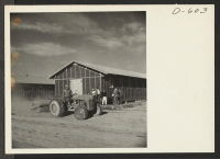 [recto] An evacuee smooths street with grading equipment at the relocation center where evacuees of Japanese descent are spending the duration. ;  Photographer: Stewart, Francis ;  Poston, Arizona.
