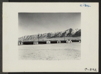 [recto] Manzanar, Calif.--View of barracks at this War Relocation Authority Center, looking southwest across the wide fire-break which is used as a recreation field. ;  Photographer: Lange, Dorothea ;  Manzanar, California.
