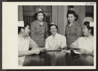 [recto] Miss Florence M. Clarke, Director of Nursing, talks with Nisei girls enrolled in the Cadet Nurse Training Corps at Kansas ...