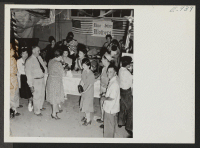 [recto] Blue Star Mothers booth at the summer carnival held in the school buildings of the Granada Relocation Center. The Blue Star Mothers gave away cake prizes and did a brisk business in Defense Stamps. ;  Photographer: Parker, Tom ;  Amache, Colorado.