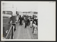 [recto] Final hand shakes through the bus windows as passengers for trip 15 to Tule Lake are about to leave the assembly point. ;  Photographer: Mace, Charles E. ;  Topaz, Utah.