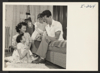 [recto] Chick Masaru Uno shows Sheila (age 6) and Naomi (age 2-1/2) a picture of their uncle, Master Sgt. Paul Uno, ...