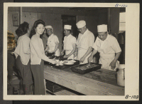 [recto] Manzanar, Calif.--Mealtime, cafeteria style, at this War Relocation Authority center. ;  Photographer: Albers, Clem ;  Manzanar, California.