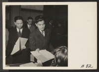 [recto] Residents of Japanese ancestry file forms containing personal data, two days before evacuation, at Wartime Civil Control Administration stations. Evacuees will be housed in War Relocation Authority centers for the duration. ;  Photographer: Lange, Dorot