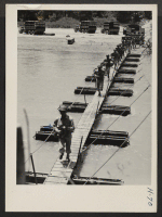 [recto] Building a Pontoon Bridge. Truck loads of infantry arriving at the river bank where they hurriedly cross the bridge to ...