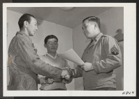 [recto] Sergeant Isamu Adachi, of the Army Recruiting Team, congratulates center residents Fred H. Kitagawa and Tommy Hiraoka on accepting their enlistment papers for duty with a special combat unit of the United States Army. ;  Photographer: Parker, Tom ;  M