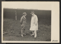 [recto] Henry T. Futamachi (left), superintendent of a 1300-acre mechanized ranch, discusses agricultural problems with the ranch owner, John B. MacKinlay. ...