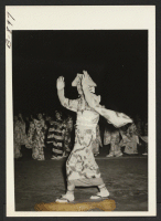 [recto] Hirotaka Okubo (foreground) at the Bon Odori dance, August 14, sponsored by the Granada Buddhist Church. Other dancers are shown in the background. ;  Photographer: McClelland, Joe ;  Amache, Colorado.