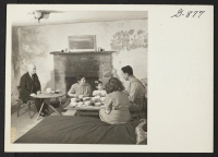 [recto] The Nakashima family and Mrs. Nakashima's father and sister from Minidoka enjoy an informal supper around a low table in ...