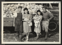 [recto] George Shoji and his wife Alice, who is holding their 1-1/2 month old son, Lynn, stand with George Ike and ...