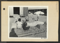 [recto] Poston, Ariz.--Evacuees of Japanese ancestry are filling straw ticks for mattresses upon arrival at this War Relocation Authority center. ;  Photographer: Clark, Fred ;  Poston, Arizona.